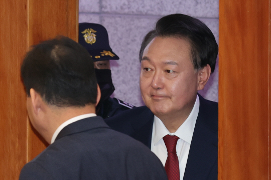 계엄 사태 이후 첫 공개석상 나선 윤석열 대통령이 희미한 미소를 머금고 있다. 사진공동취재단