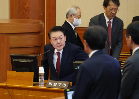 윤 대통령이 양복 차림에 넥타이를 착용하고 탄핵심판 3차 변론이 열리는 대심판정으로 입정하고 있다. 사진공동취재단