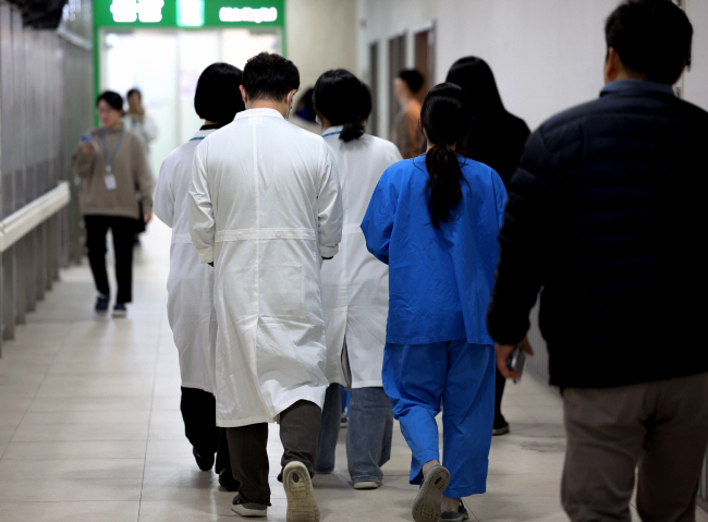 서울대의대 본과 3·4학년 정원의 약 30%가 새 학기 수업을 듣기 위해 학교로 복귀한 가운데 20일 서울 한 대학병원에서 의료진이 이동하고 있다.   뉴시스