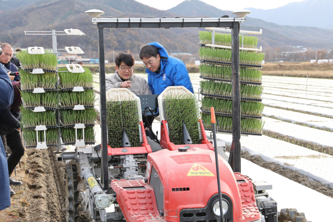농촌진흥청이 밭 농업 기계화로 농산업 현장 애로 해소에 나선 가운데 권재한(왼쪽) 농촌진흥청장이 지난해 12월 3일 경남 함양군에서 열린 ‘노지 양파 생산을 위한 스마트농업 연시회’(농업 관련 생산 방법·기술을 보여주는 모임)에서 무인 양파 정식기를 살펴보고 있다.  농촌진흥청 제공