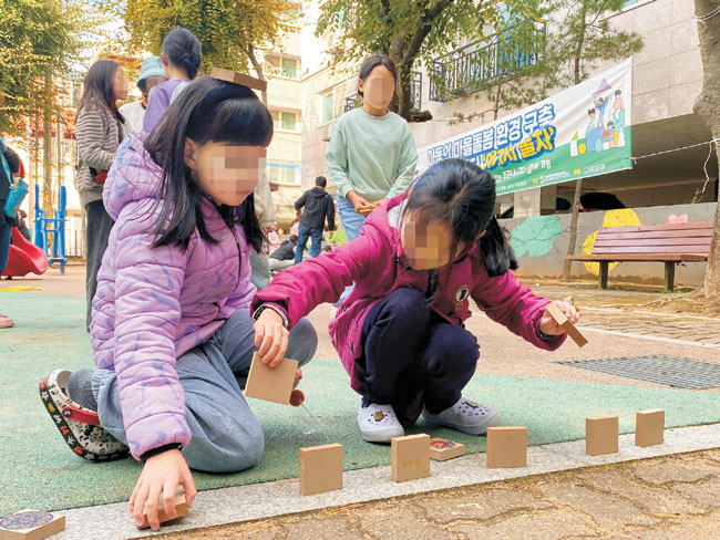 경기 안산시 단원구 선부2동 땟골 공원에서 진행된 선부종합사회복지관의 ‘안전한 놀이터, 여기서 놀자’ 사업에 참여한 어린이들이 지난해 10월 나무 놀잇감을 가지고 전통놀이를 하고 있다. 초록우산 제공