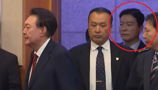 김성훈 대통령 경호처 차장이 지난 21일 서울 종로구 헌법재판소 대심판정에 출석한 윤석열 대통령을 경호 중이다. 빨간 원으로 표시된 인물이 김 차장. 연합뉴스TV 보도화면 캡처