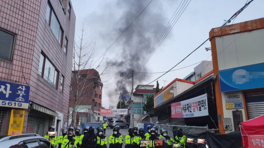 지난 2020년 11월 26일 철거 문제를 놓고 갈등을 빚어오던 서울 성북구 장위동 사랑제일교회 명도 집행 당시 화염병을 던지거나 몸에 인화물질을 뿌리며 반발하는 신도들로 인해 주변에서 연기가 치솟고 있다. 연합뉴스