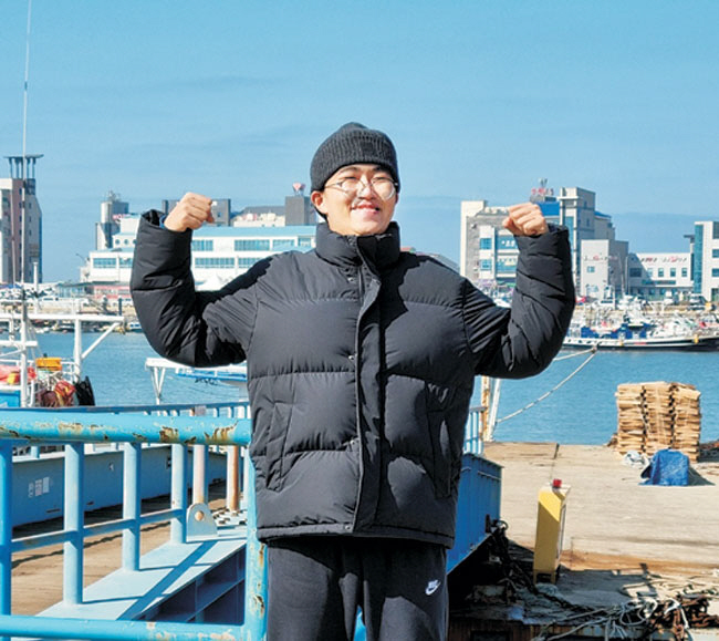 지난해 12월 말 대학 합격을 기념해 전북 군산의 한 바닷가로 가족여행을 갔던 조용준(24) 씨가 두 팔을 들어올려 힘을 주며 웃고 있다. 조용준 씨 제공