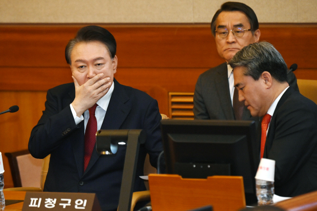 윤석열 대통령이 6일 오전 서울 종로구 헌법재판소에서 열린 탄핵심판 6차 변론기일에 출석해 입을 가린 채 변호인에게 말을 하고 있다. 윤성호 기자