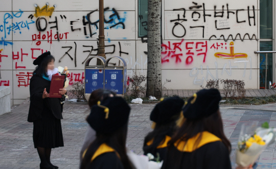 지난 21일 서울 동덕여대에서 열린 학위수여식에서 졸업생들이 기념촬영을 하고 있다. 동덕여대는 지난해 11월 남녀공학 전환 관련 학생들의 래커칠 등 시위로 인한 학교 측 피해 보상 문제로 의견 대립 중이다. 연합뉴스