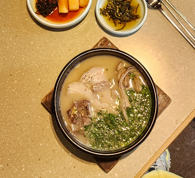 엄용백돼지국밥에서 내는 뽀얀 국물의 밀양식 국밥. 진하고 무거운 국물 맛이 인상적이다.