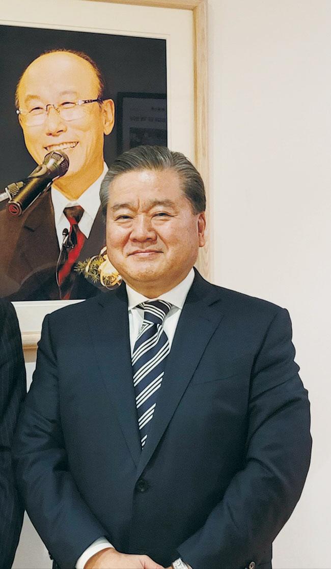 시가키 시게마사 목사가 순복음동경교회 당회장실 앞에 있는 조용기 목사 사진 앞에서 찍은 사진.