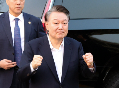윤석열 대통령이 지난 8일 오후 석방된 뒤 한남동 관저 입구에 도착해 지지자들을 향해 주먹을 쥐어 보이고 있다. 뉴시스