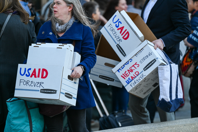 미국 국제개발처(USAID) 공무원과 시민들이 지난달 28일 워싱턴DC USAID 건물 앞에서 해고될 때 짐을 담아 나르는 종이상자에 ‘USAID 영원히’라는 문구를 적고 정부의 USAID 폐지 방침에 반대하는 시위를 벌이고 있다. UPI 연합뉴스