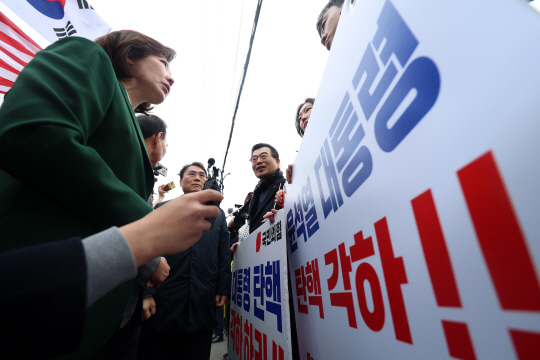 나경원 의원 등 국민의힘 의원들이 12일 오전 서울 종로구 헌법재판소 앞에서 ‘국민의힘 탄핵반대 당협위원장 모임’ 위원들을 격려하고 있다. 뉴시스