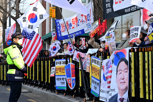 13일 오전 서울 종로구 헌법재판소 인근에서 윤석열 대통령 탄핵 반대 시위대가 태극기를 들고 ‘탄핵 무효’ 등을 외치고 있다. 문호남 기자