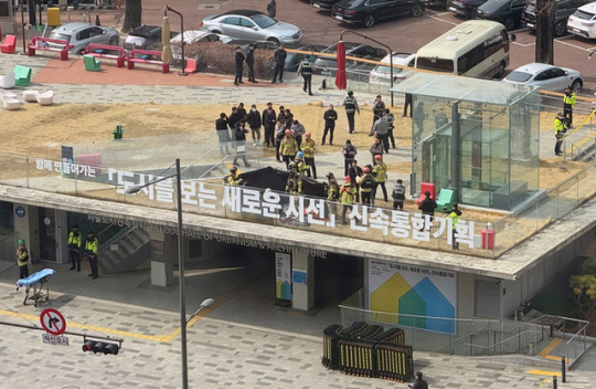 지난 7일 낮 서울 중구 도시건축전시관 옥상에서 소방관들이 윤석열 대통령 지지자로 추정되는 한 남성의 분신 시도 현장을 수습하고 있다. 연합뉴스