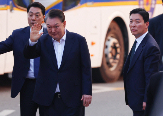 석방된 윤석열 대통령이 지난 8일 경기도 의왕시 서울구치소 앞에서 경호차량에서 내려 지지자들에게 인사하고 있다. 그 옆으로는 김성훈 경호처 차장(오른쪽)이 윤 대통령을 경호하며 이동하는 모습. 연합뉴스