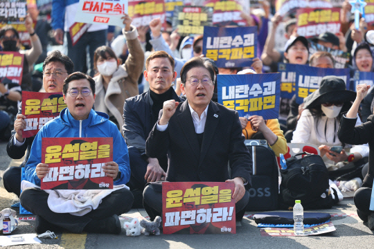 이재명(왼쪽 두번째) 더불어민주당 대표와 박찬대(왼쪽 첫번째) 원내대표가 22일 서울 종로구 동십자각 앞에서 열린 야5당 공동 비상시국 범국민대회에서 구호를 외치고 있다. 연합뉴스