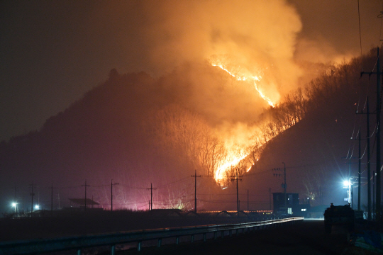 22일 오후 10시34분 전날 경남 산청에서 발생한 산불이 산등성이를 타고 주택가로 확산되고 있다. 뉴시스