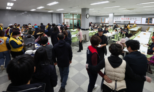 경남 산청에서 올해 들어 처음으로 발생한 대형 산불이 이틀째로 접어든 22일 산청군 한국선비문화원에서 이재민과 자원봉사자들이 식사하고 있다. 연합뉴스
