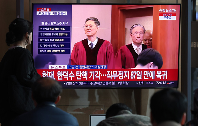 헌법재판소가 24일 한덕수 대통령 권한대행 국무총리에 대한 국회의 탄핵소추를 기각한 가운데 이날 오전 서울 용산구 서울역 대합실에서 시민들이 관련 속보를 시청하고 있다. 뉴시스