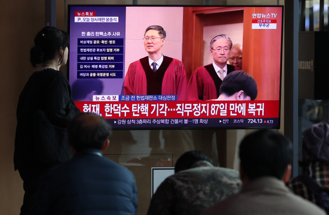 헌법재판소가 24일 한덕수 대통령 권한대행 국무총리에 대한 국회의 탄핵소추를 기각한 가운데 이날 오전 서울 용산구 서울역 대합실에서 시민들이 관련 속보를 시청하고 있다. 뉴시스