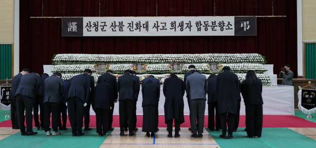 24일 오전 경남 산청군 산불로 숨진 희생자 4명의 합동분향소가 차려진 창녕군민체육관에서 추모객들이 묵념을 하고 있다. 연합뉴스