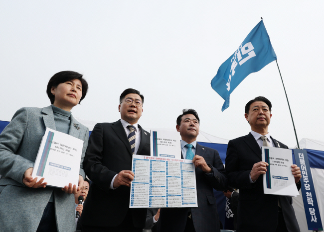 박찬대(왼쪽 두 번째) 더불어민주당 원내대표가 25일 오전 서울 광화문 천막당사에서 3선 국회의원들이 만든 ‘윤석열이 파면돼야 하는 101가지 이유-윤석열 정부 실정 101 백서’를 전달받고 있다. 왼쪽부터 백혜련 의원, 박 원내대표, 박정·김영호 의원. 박윤슬 기자