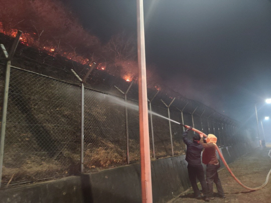 지난 25일 경북 청송군 경북북부 제2교도소에서 교도소 인근까지 번진 산불을 막기 위해 직원들이 물을 뿌리고 있다. 법무부 교정본부 제공.