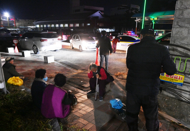25일 경북 안동시 전역에 산불이 확산하면서 전 주민 대피령이 내려진 가운데 임시 대피소가 마련된 안동초 앞에 수용인원 초과로 들어가지 못한 고령의 이재민들이 길바닥에 앉아 있다. 윤성호 기자