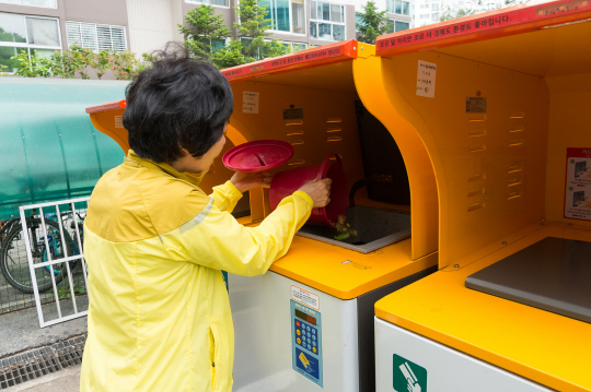 서울 양천구 한 아파트에서 주민이 음식물류폐기물 RFID 종량기에 음식물을 배출하고 있다. 양천구청 제공